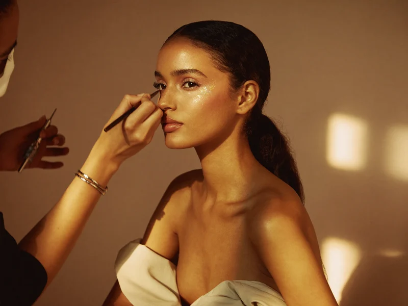 Kreativ makeup med stærk farve og glimmer på øjenlåg og kindben